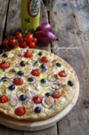 Pizza semi-integrale con tonno, pomodorini, olive nere, cipolle e parmigiano