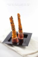 Idea finger food: grissini di patate al sesamo nero con speck arrotolato