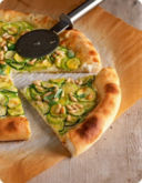 Pizza al cornicione con zucchine, caprino e pinoli.