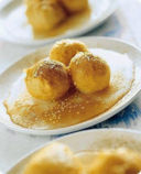 Palline fritte con sciroppo di miele e sesamo.