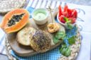 Hamburger di pesce con salsa alla papaya, crema di formaggio al wasabi e spinacini novelli