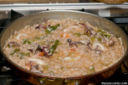 Padella di riso Baldo in risotto con calamari, gamberi e carciofi.