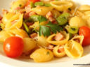 Conchiglie di pasta con fave, prosciutto e pomodorini