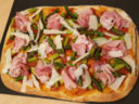 Pizza con asparagi, speck cotto e scaglie di parmigiano